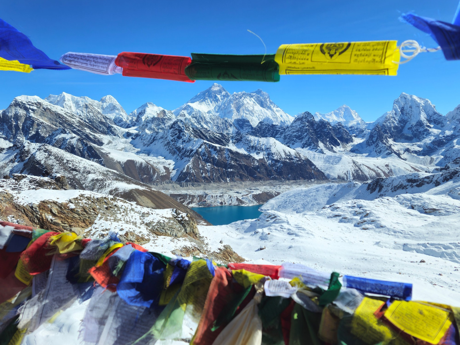Colorful prayer flags above a snow-covered Himalayan mountain range in Nepal
